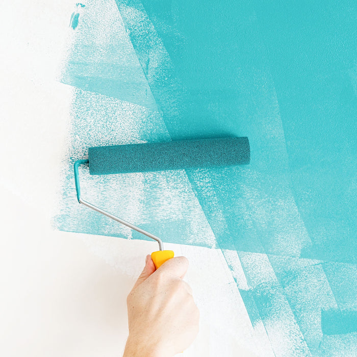 Blaue Wandfarbe wird mit Farbrolle aufgetragen